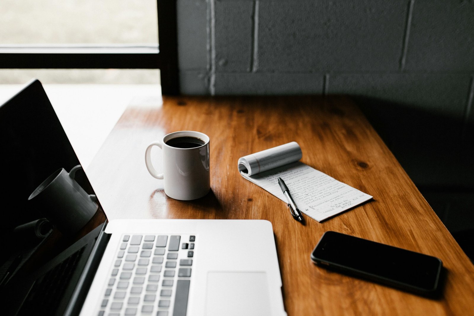macbook pro, white ceramic MacBook Pro, white ceramic mug,and black smartphone on table