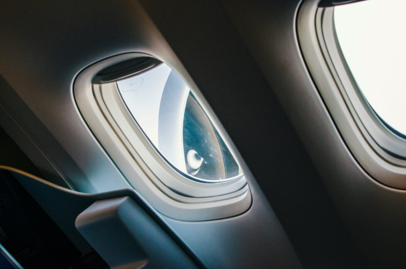 an airplane window with an airplane window with a person looking out the window