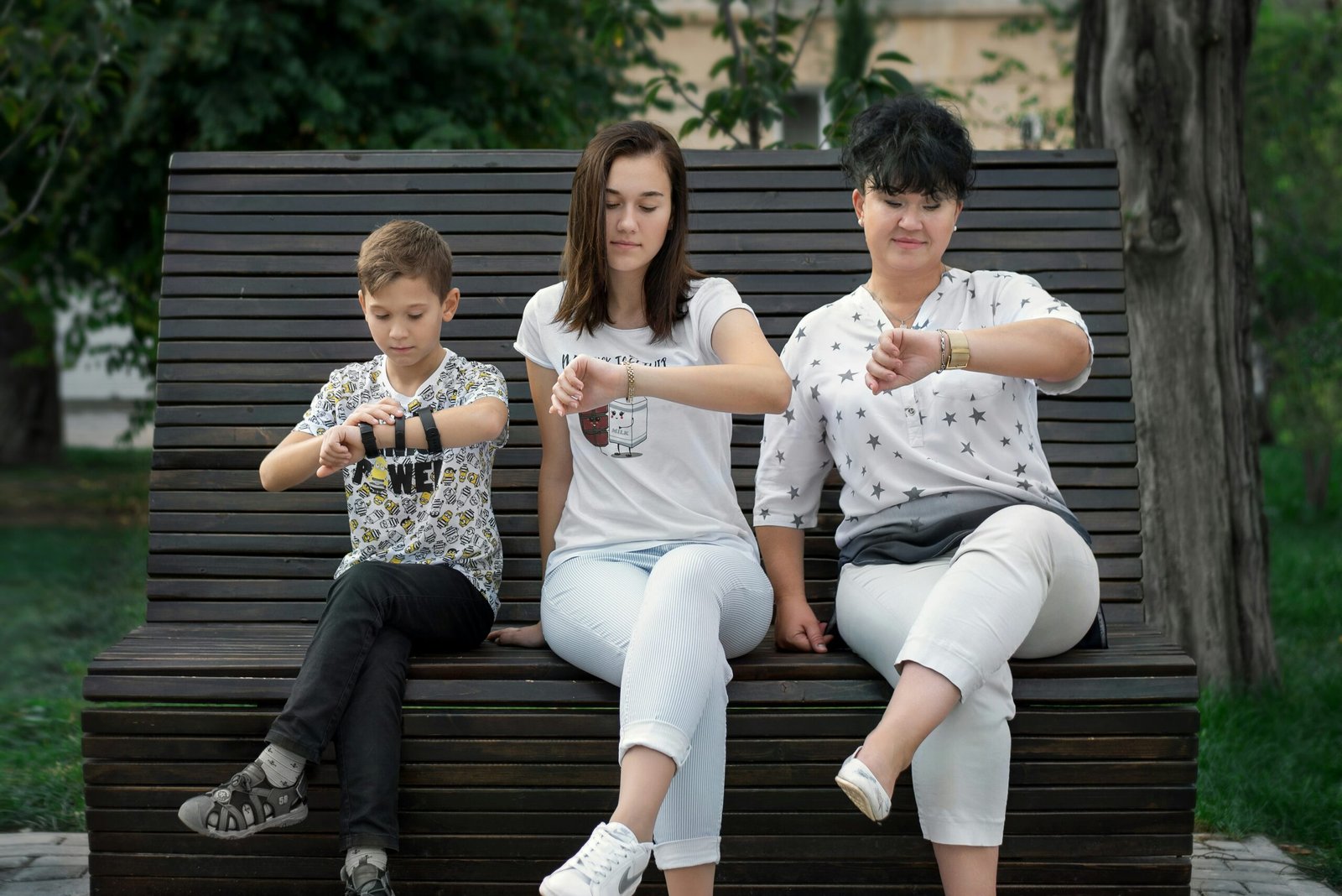 man and woman sitting man and woman sitting on brown wooden bench